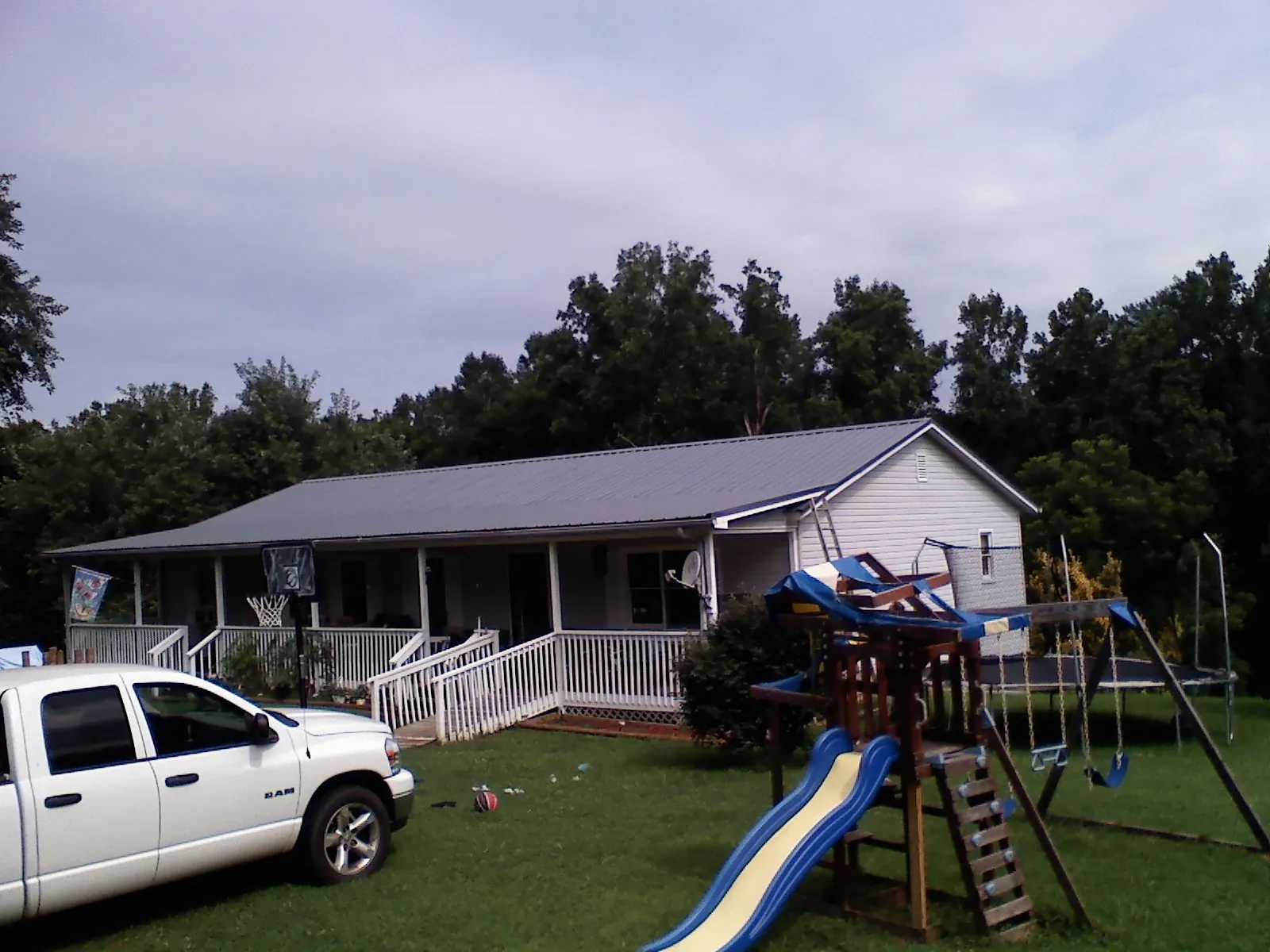 Dark metal roof on a country home with a full length front porch in George