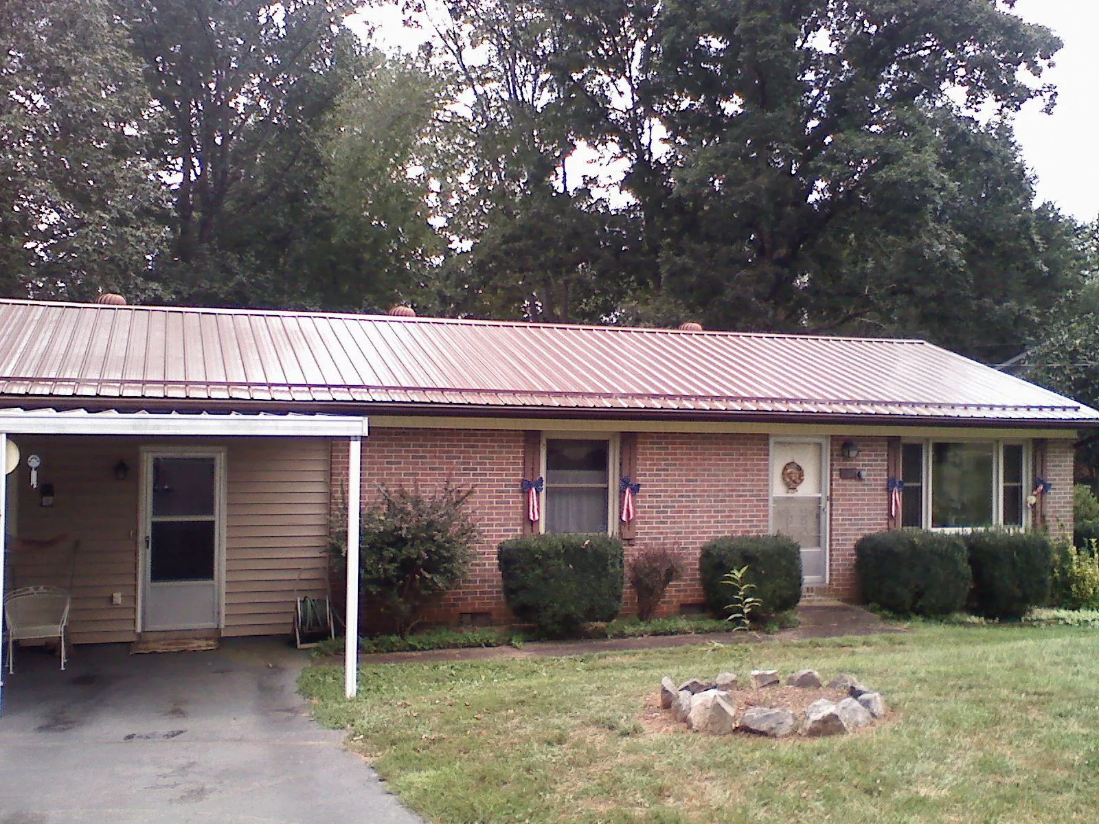 Bronze metal roof and carport on a brick ranch home — Roof Repair work by our crew in George